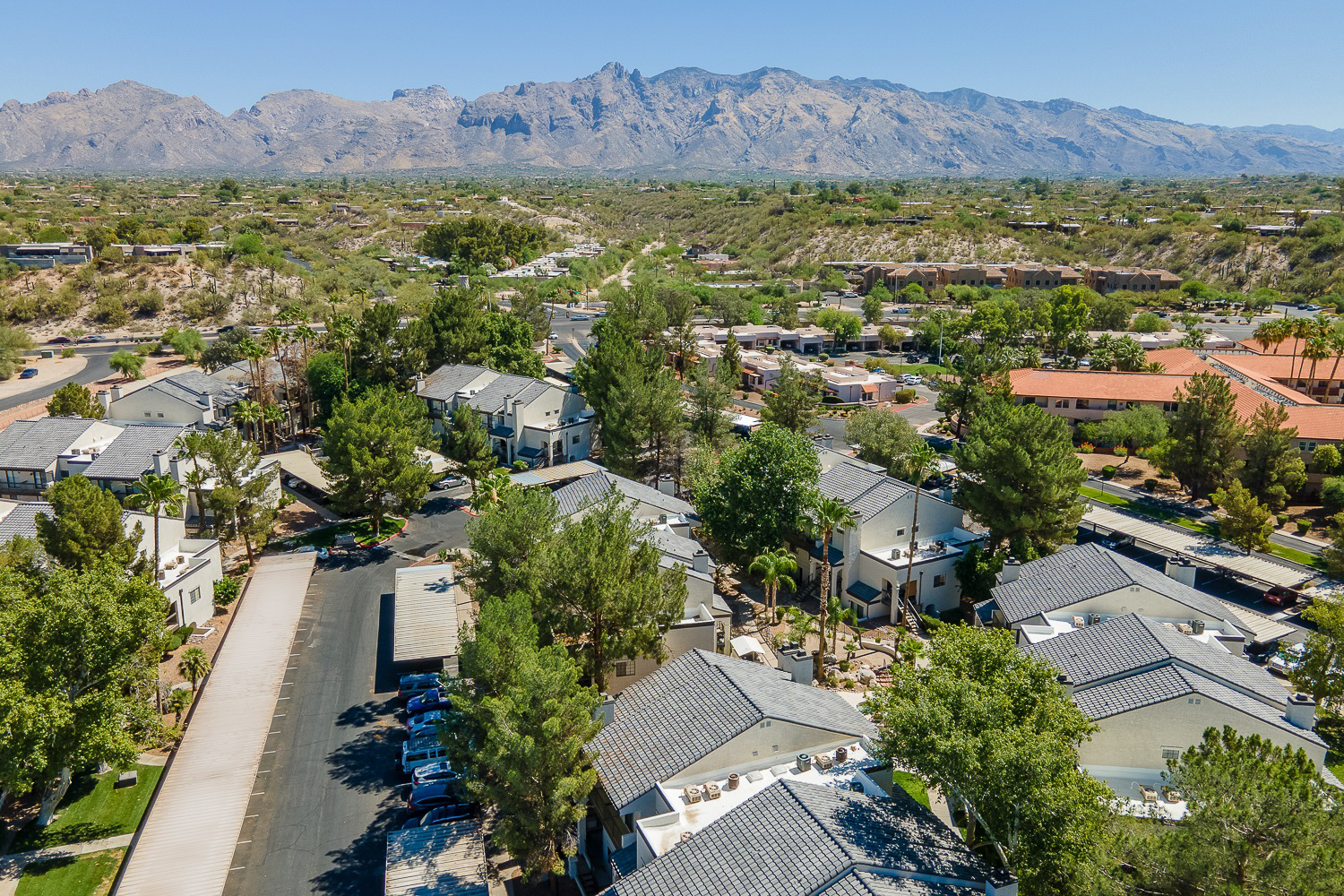 Exterior drone photo of ENVii apartments, with desert and and mountain range in the background
