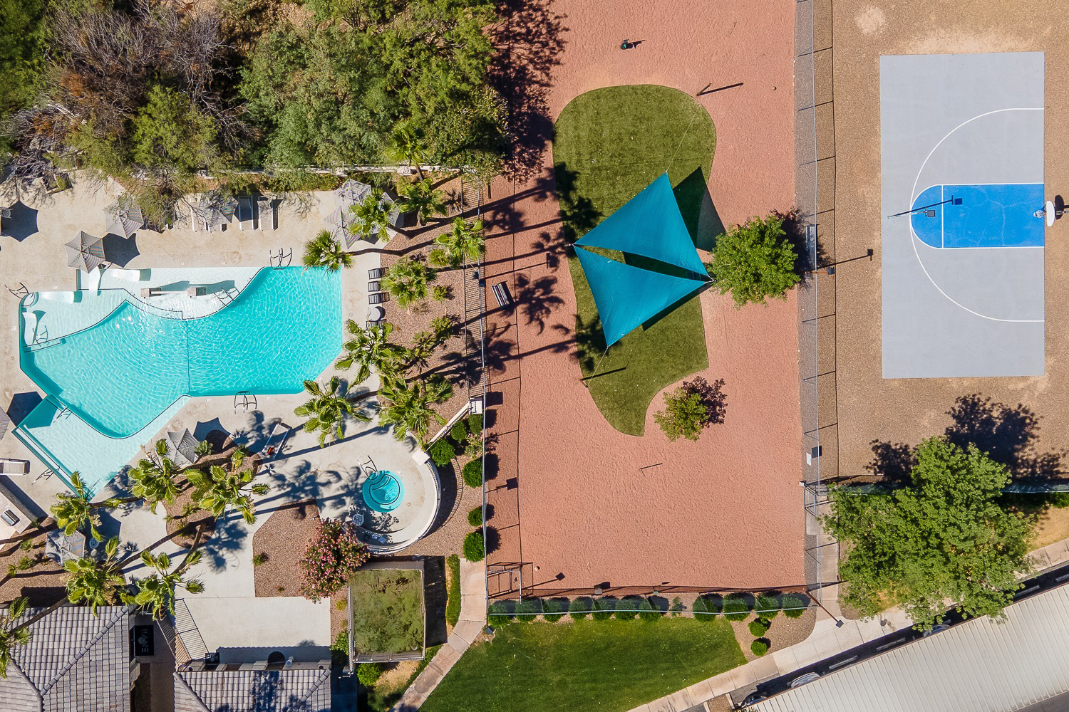 Drone photograph looking down on a pool and basketball court