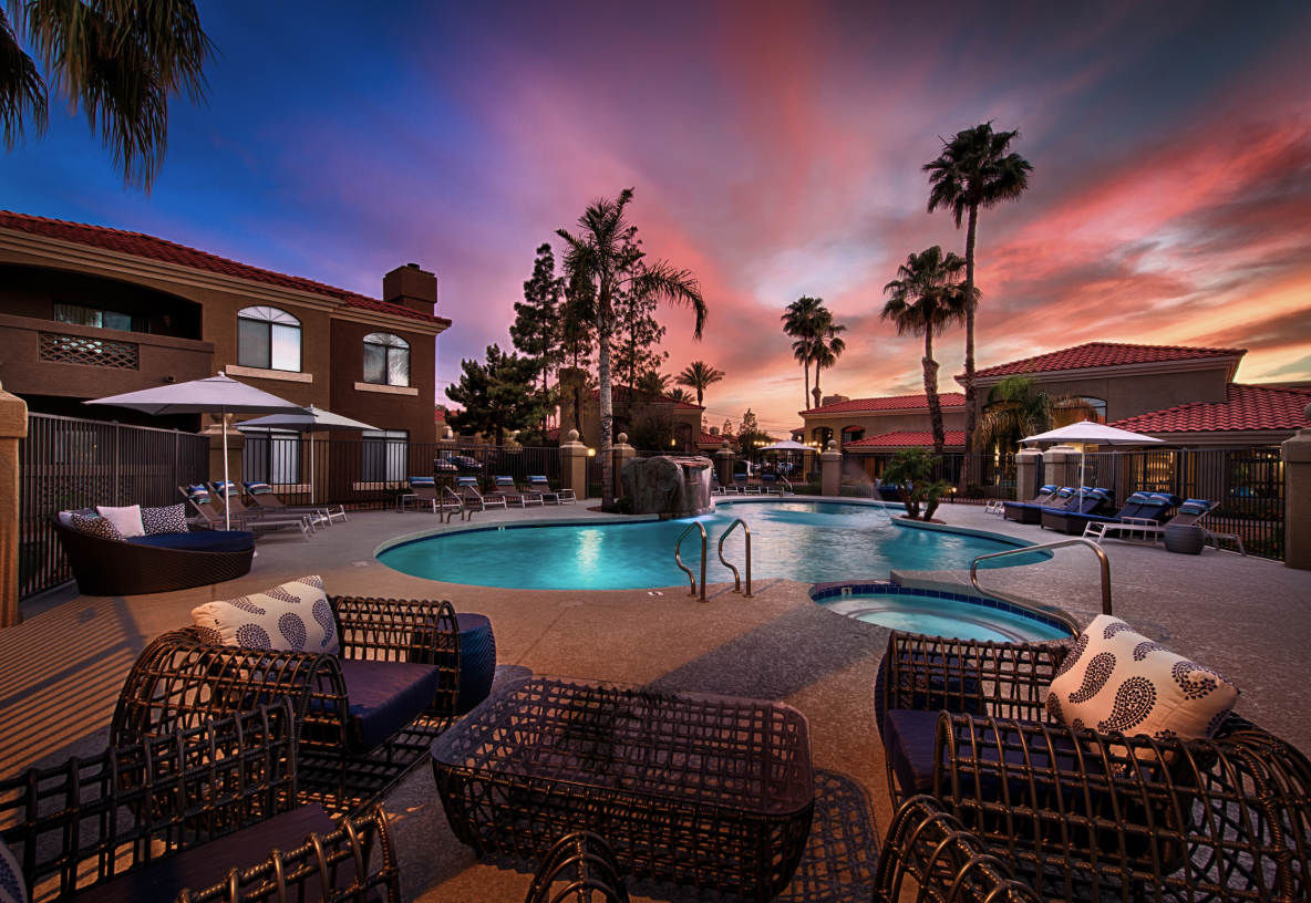 Photo of pool and patio at night with palm trees