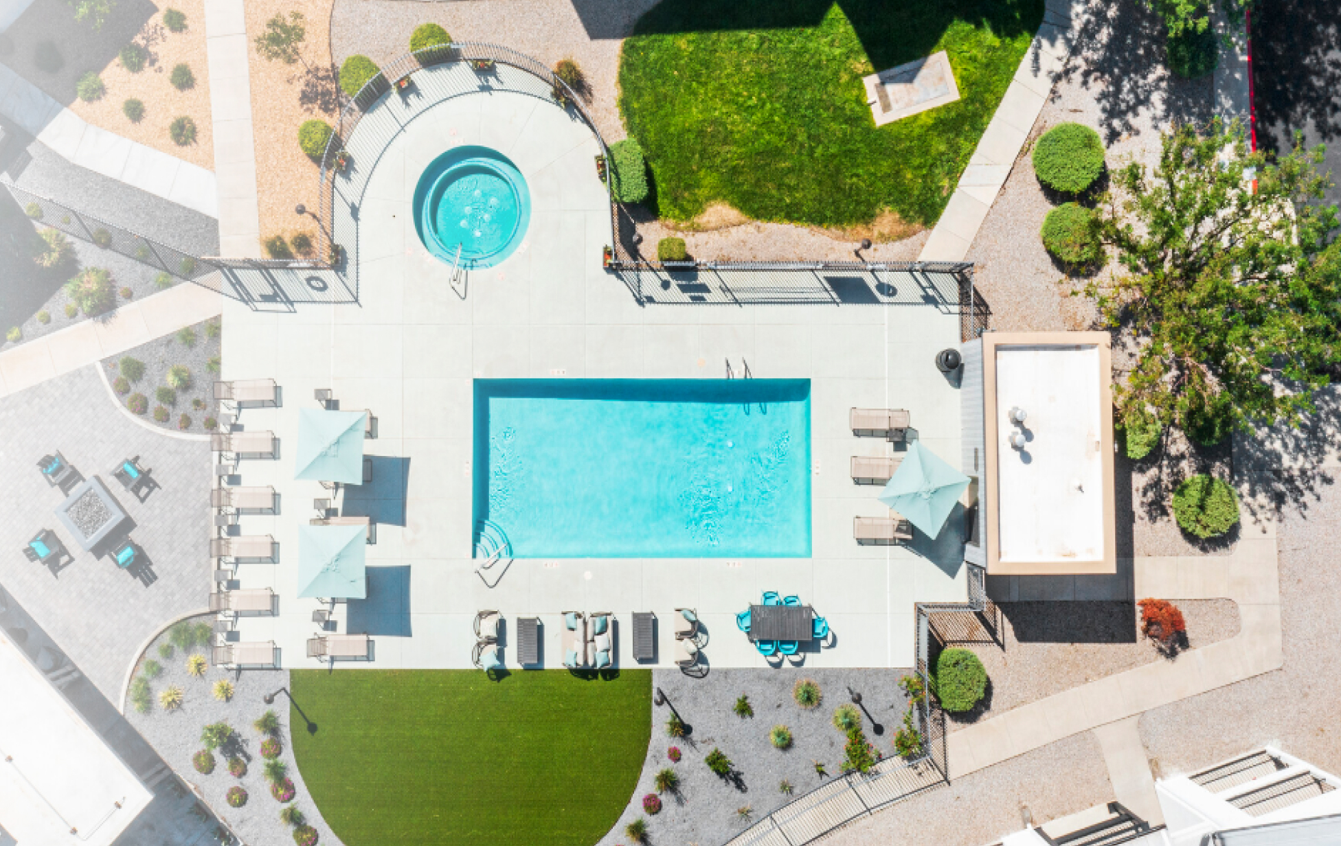 A drone camera shot looking down on an outdoor pool and patio.