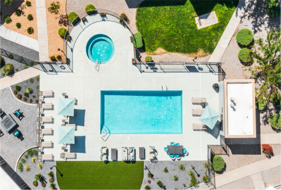 Drone shot looking down on an outdoor pool and patio.