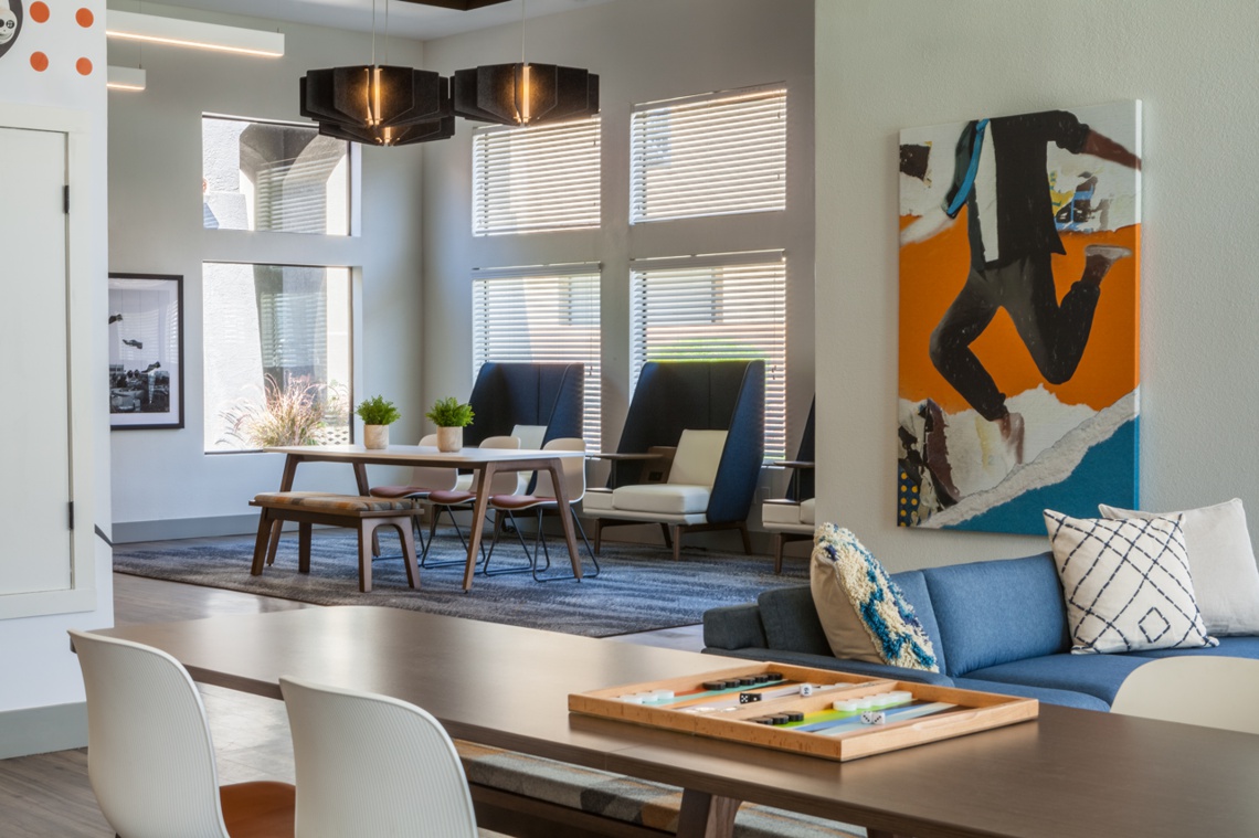 Large wood table in communal area with a smaller dining table in the background