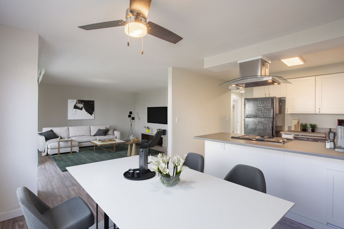 Dining room with table and chairs, with living room and television in the background
