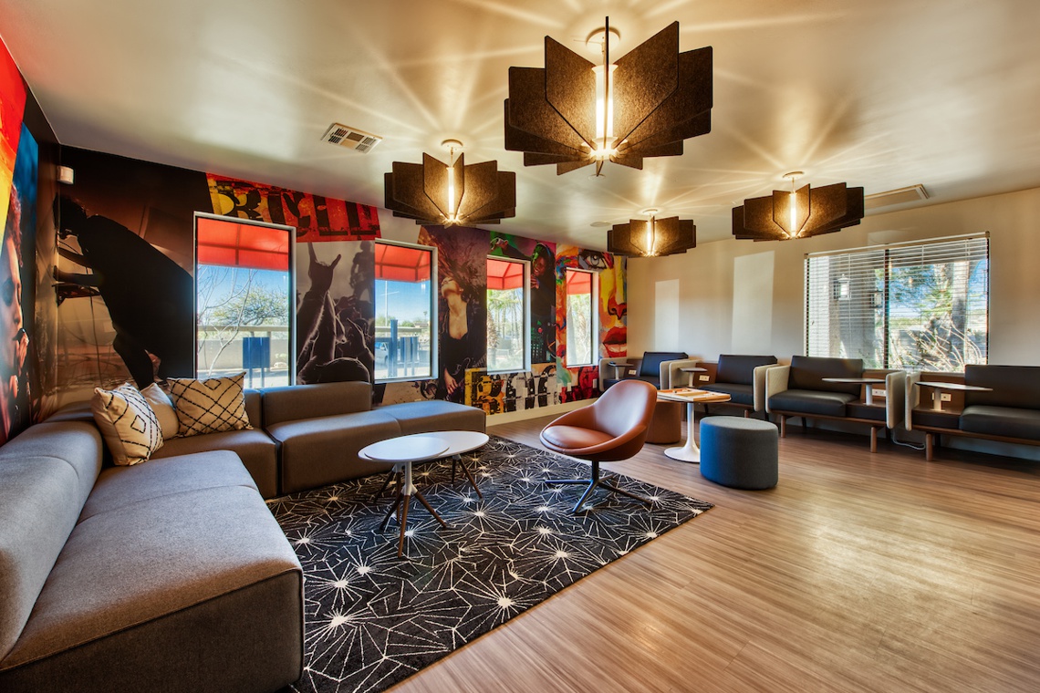 Member clubhouse with lounge seating, pendant lamps, and art wall